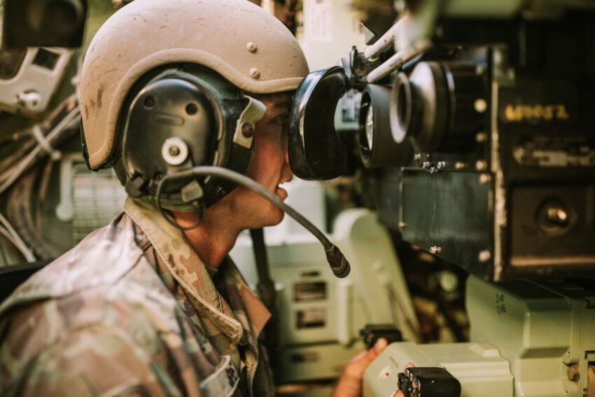 Service member using communications equipment inside a military vehicle